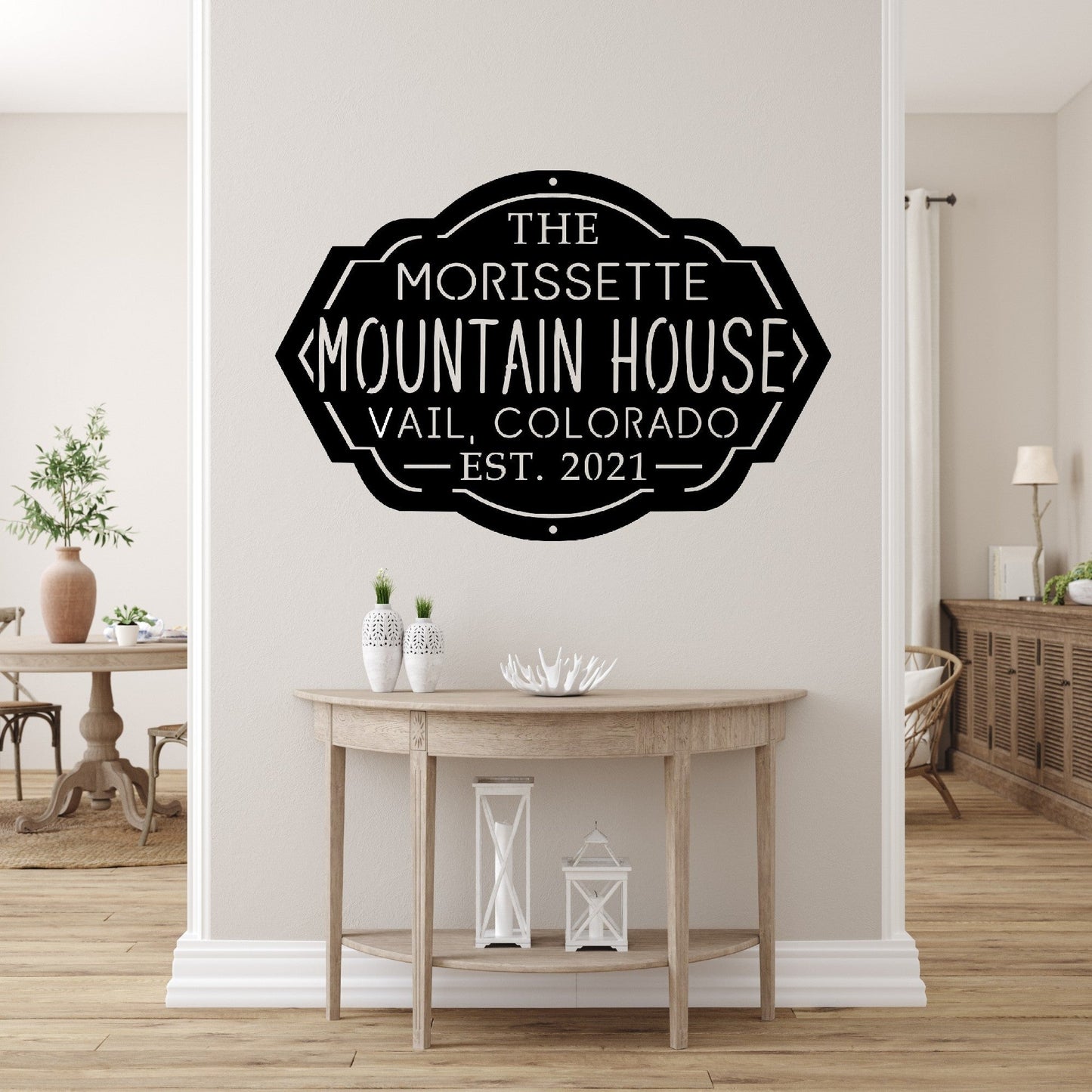 Front entryway of a house with a custom metal sign for a mountain house on the wall above a table