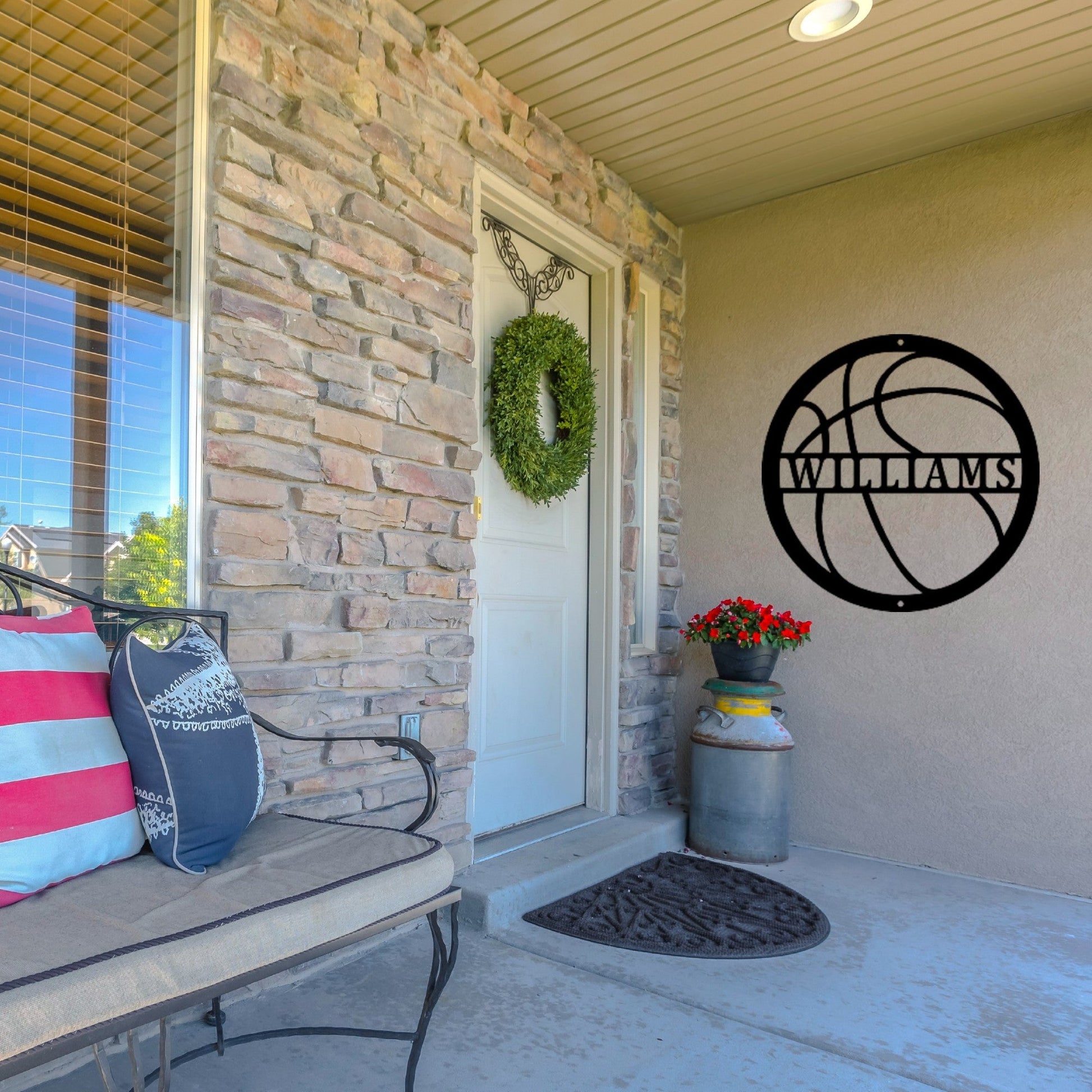 Front porch of a house with a custom metal sign in the shape of a basketball next to the door
