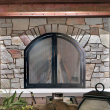 Load image into Gallery viewer, Stone fireplace with an arched metal fireplace screen featuring doors, adding both style and functionality to the rustic hearth setting