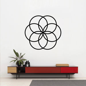 The Cerelia Metal Circles Wall Decor is hung above a bold red desk, creating a striking contrast between the modern artwork and the vibrant furniture. 