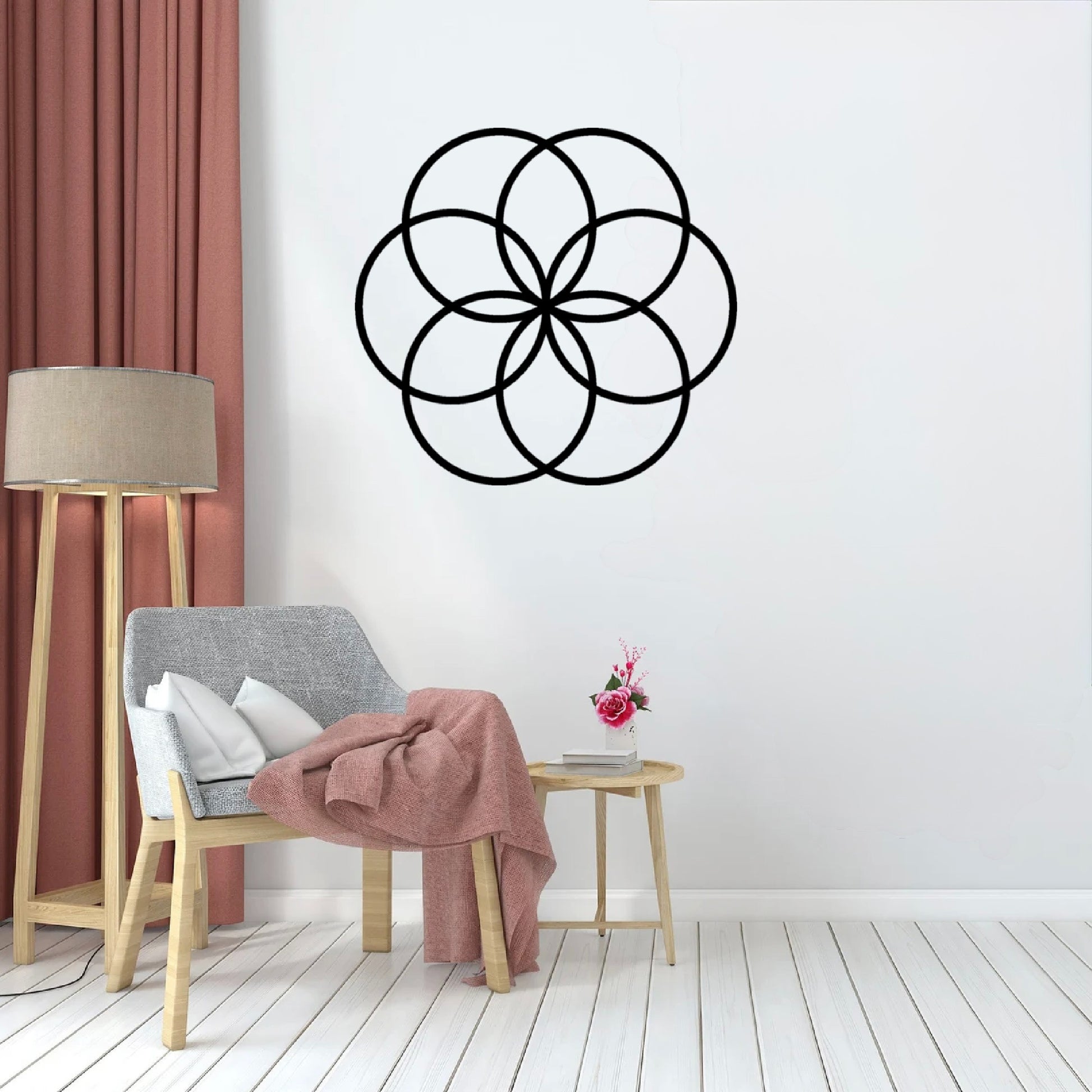 In the studio type room, the Cerelia Metal Circles Wall Decor is hung prominently on the wall, acting as a striking focal point. The circles’ smooth, adding a touch of sophistication and depth to the space.