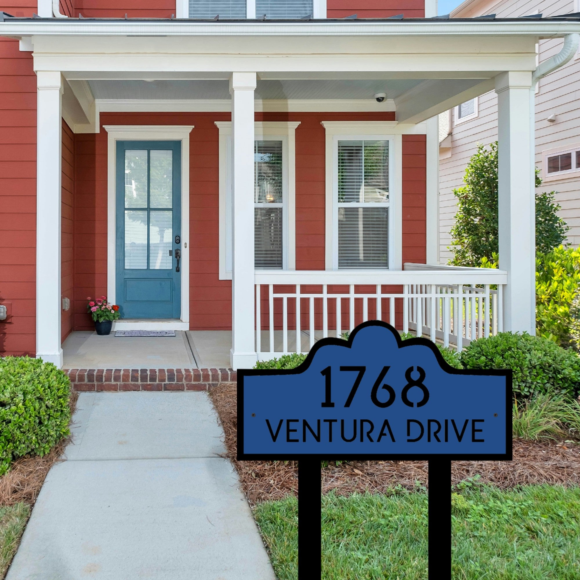 The Double Layer Luxury Address Yard Sign stands out in the front yard, on the right side of the concrete path that leads to the house. The sign is beautiful and strong, and it has a unique two-layer look. The front layer is a deep, rich blue with black text. The outline and support posts are black, making a stylish contrast.