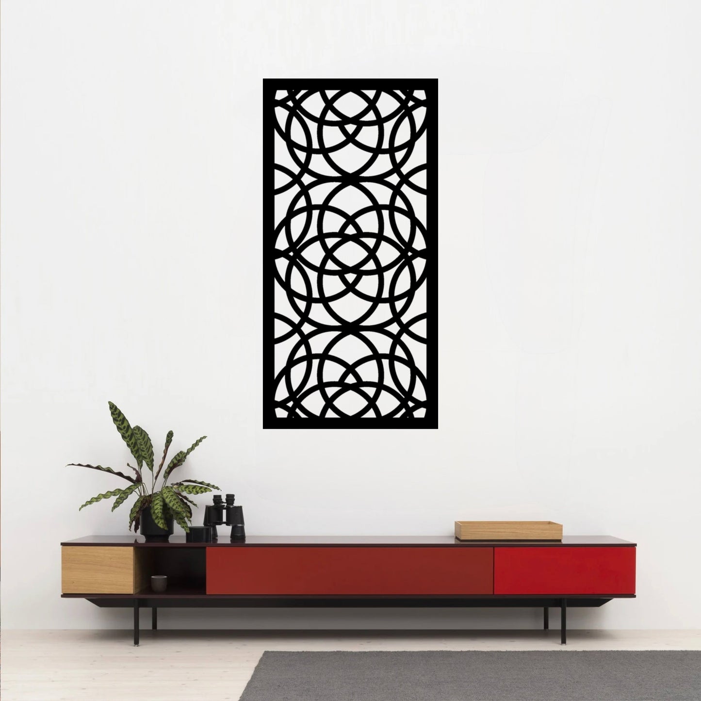 The Ellara Metal Wall Art is prominently displayed on the wall above or near a red desk, creating a striking and dynamic visual contrast.