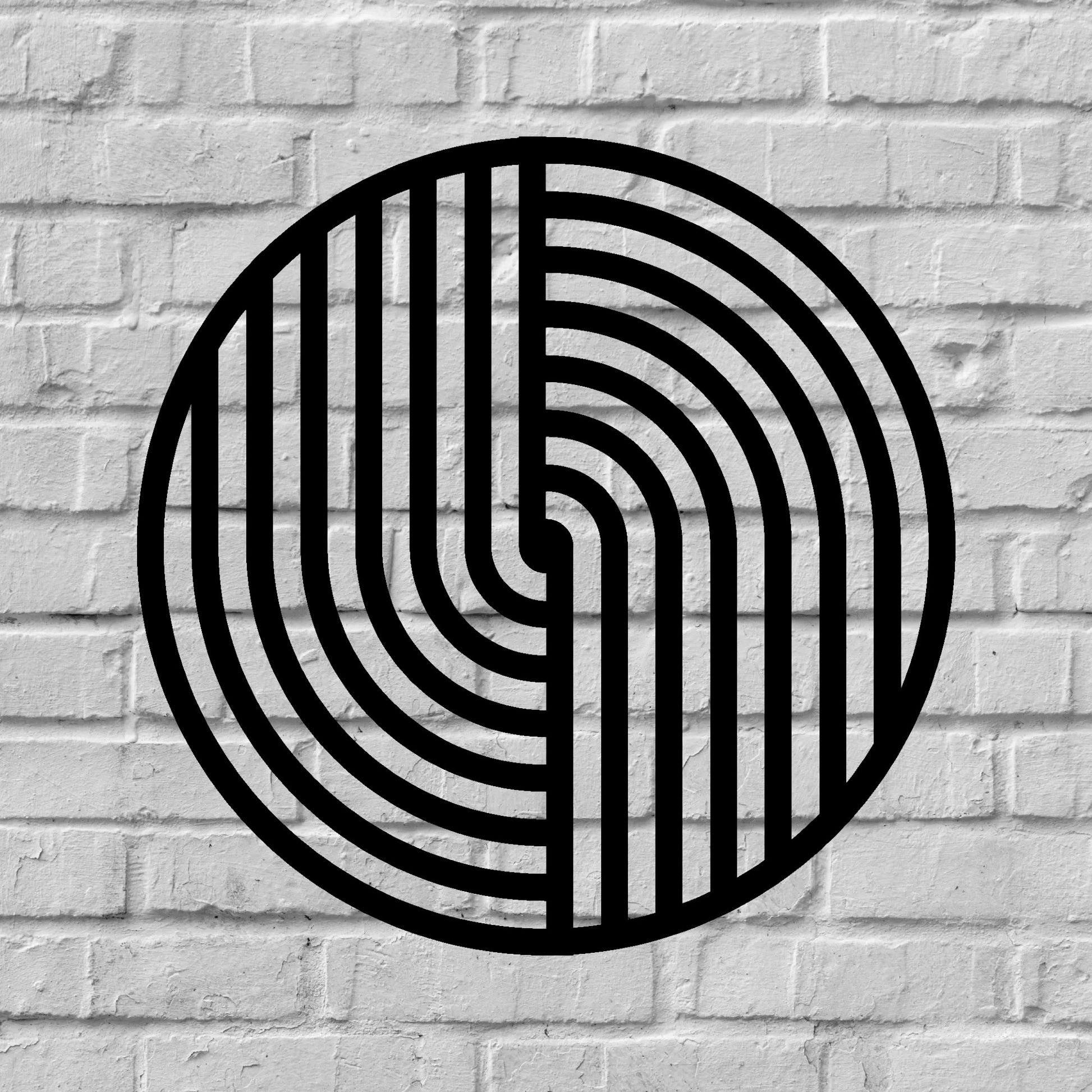 The image features a round metal wall art piece with a bold black geometric pattern, mounted on a textured white brick background. The contrast between the sleek, modern design of the artwork and the rustic, industrial feel of the brick wall creates a visually striking and stylish aesthetic.