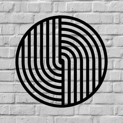 The image features a round metal wall art piece with a bold black geometric pattern, mounted on a textured white brick background. The contrast between the sleek, modern design of the artwork and the rustic, industrial feel of the brick wall creates a visually striking and stylish aesthetic.
