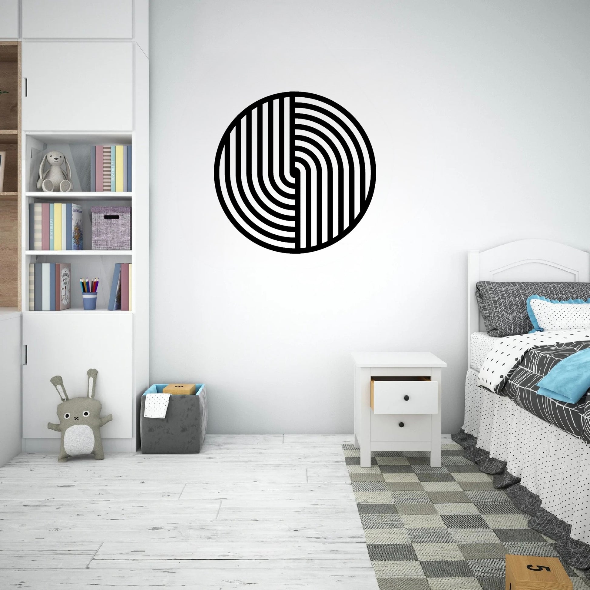 The image showcases a modern and cozy children's bedroom with a round metal wall art piece featuring a bold black geometric design hanging above a white nightstand.