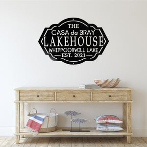 Entryway of a house with a table and a lake house sign on the wall above the table