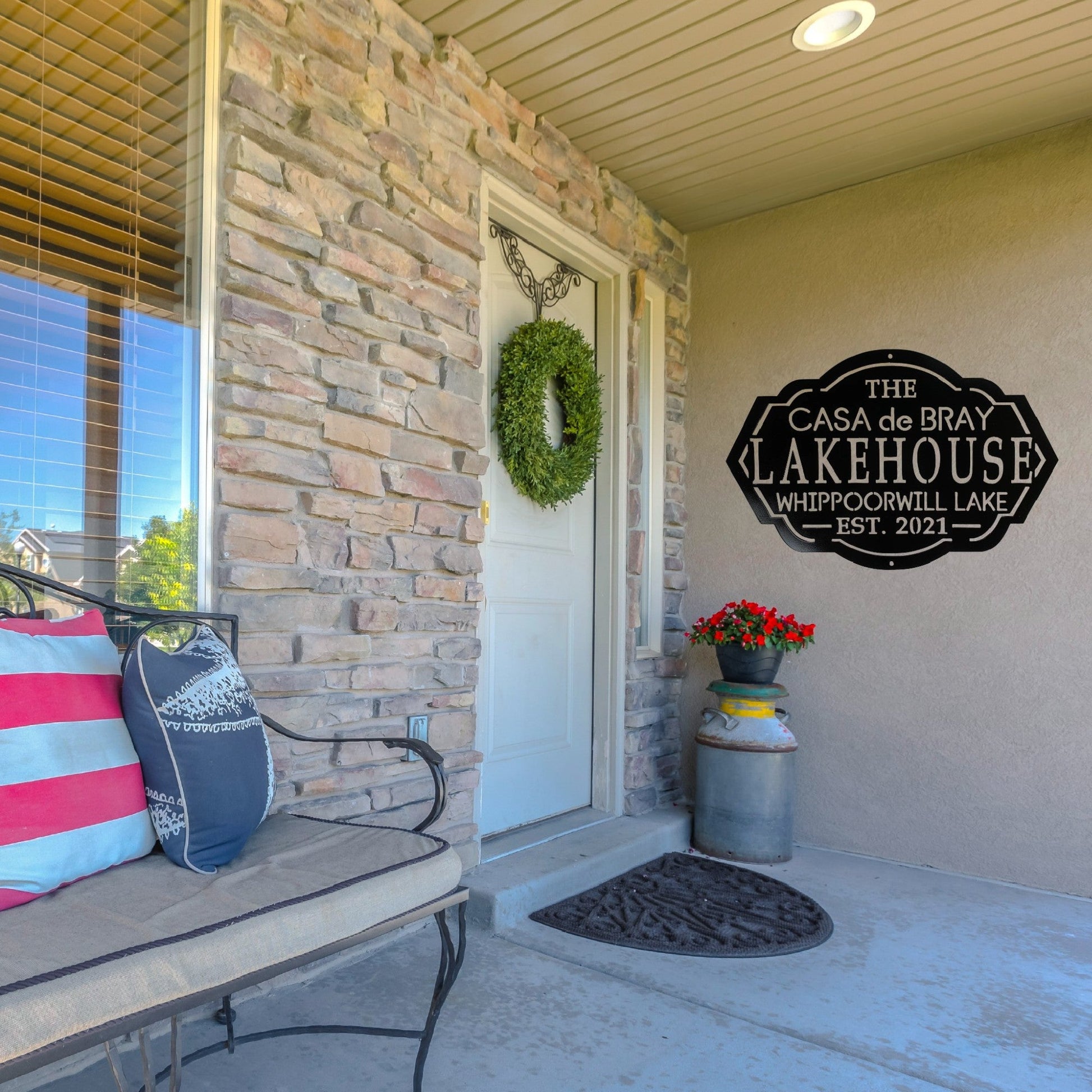 Front porch of a house with a custom lakehouse sign on the wall