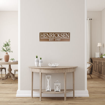 House entryway with an aged copper custom family name sign with established date