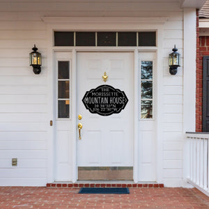 Front door of a house with a black custom metal mountain house sign