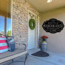 Load image into Gallery viewer, Front porch of a house with a custom metal mountain house sign on the wall
