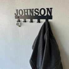 Load image into Gallery viewer, custom family name coat rack on a wall with coat and key hanging on it