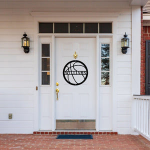 Front door of a white house with a custom metal sign in the shape of a basketball on the door