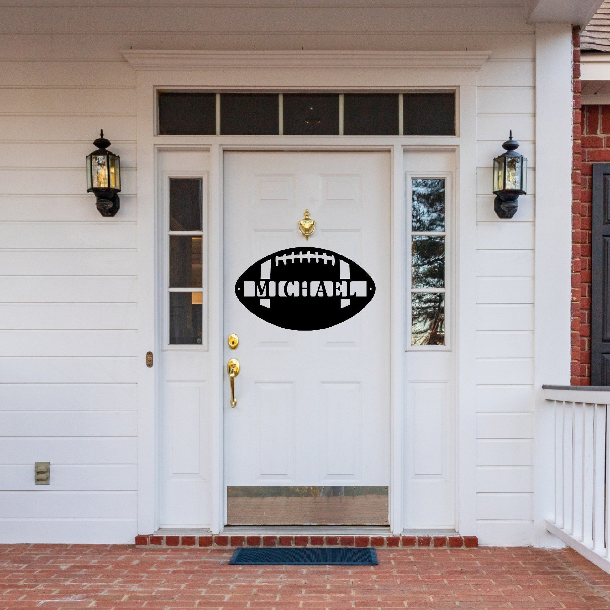 Front door of a white house with a custom metal sign in the shape of a football on the door