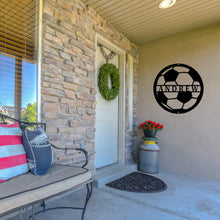 Load image into Gallery viewer, Front porch of a house with a bench and wreath on the door, next to the door is a custom metal sign in the shape of a soccer ball in black paint