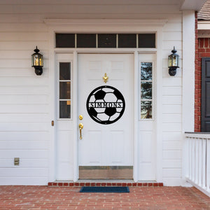 Custom metal sign in the shape of a soccer ball on the front door of a house