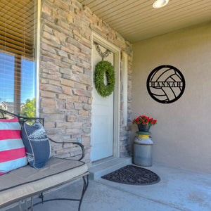 Front porch of a house with a custom metal sign in the shape of a volleyball on the wall