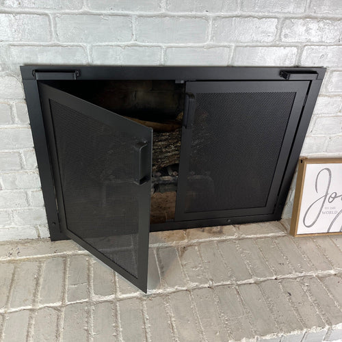 fireplace screen with doors with one door open to show the inside of the fireplace