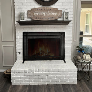 Large fireplace screen in front of a fireplace with a fire